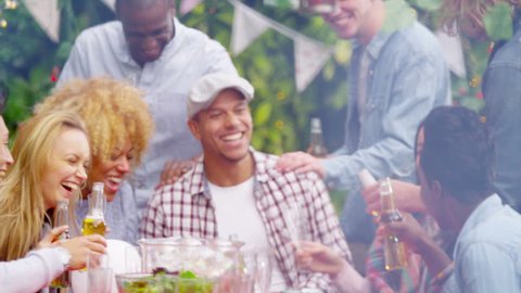 4K Happy mixed ethnicity group of friends laughing & drinking beer at bbq party. Shot on RED Epic.