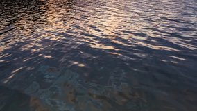 Background of ripples on lake surface in sunrise light. Full HD RAW video