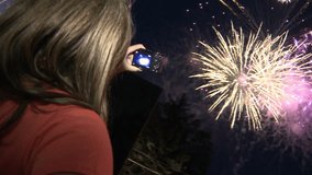 Woman filming fireworks video with her camera