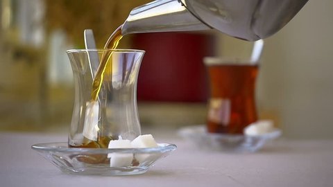 Serving Turkish tea with sugar cubes and a teaspoon. Turkish Tea served from traditional 2 tiered teapot. (Bottom one for boiling water and top pot for brewed tea).
