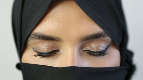 The eyes of an Arab woman show through her black abaya.