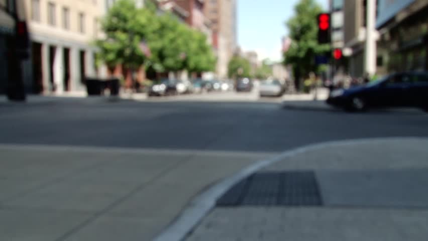 Raleigh, North Carolina focus-in cross street with oncoming traffic, pedestrians, american flags, and bus crossing