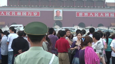 Beijing, China - June 2010: Chinese soldier and crowds of people in front of the Tiananmen Gate with picture of Mao Zedong. Beijing, China.
