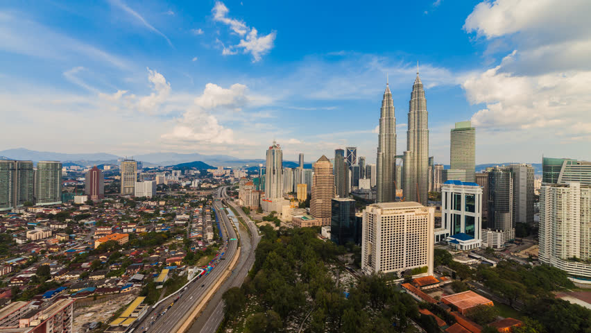 Time lapse: Kuala Lumpur city skyline view during clear blue skies in the afternoon overlooking the Tun Razak road and AKLEH highway
