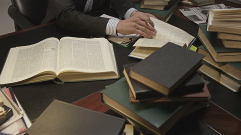 Businessman working and exploring books in the working room. Shot on RED EPIC Cinema Camera.