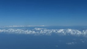 Video UHD - Airborne shot of a layer of puffy. white. cottony clouds. drifting over a vast epanse of open ocean far below.