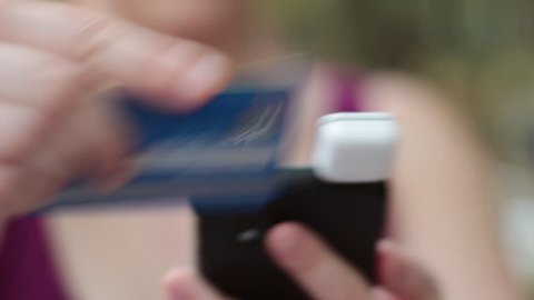 Swiping credit card in Square smartphone attachment.