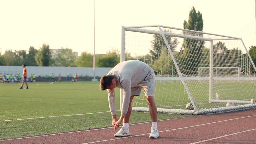 young athlete doing a warm up leg stretch before a race.