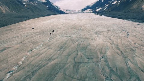 4K Aerial drone shot of Athabasca Glacier over hikers.
