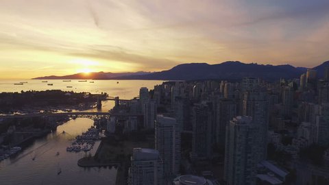4K aerial backward shot of Vancouver Skyline at sunset.