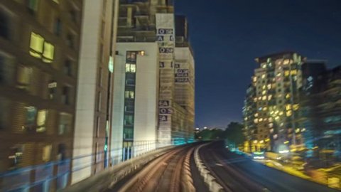 Time lapse of the Docklands in London in motion from a fast moving train at night, technique called hyperlapse