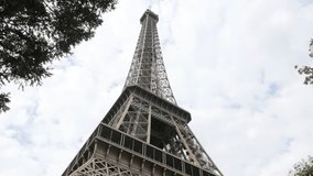 Tilt on French symbol of Champ de Mars in Paris by the day 4K 2160p 30 fps UltraHD footage - Eiffel tower lattice construction against cloudy blue sky 4K 3840X2160 UHD tilting video
