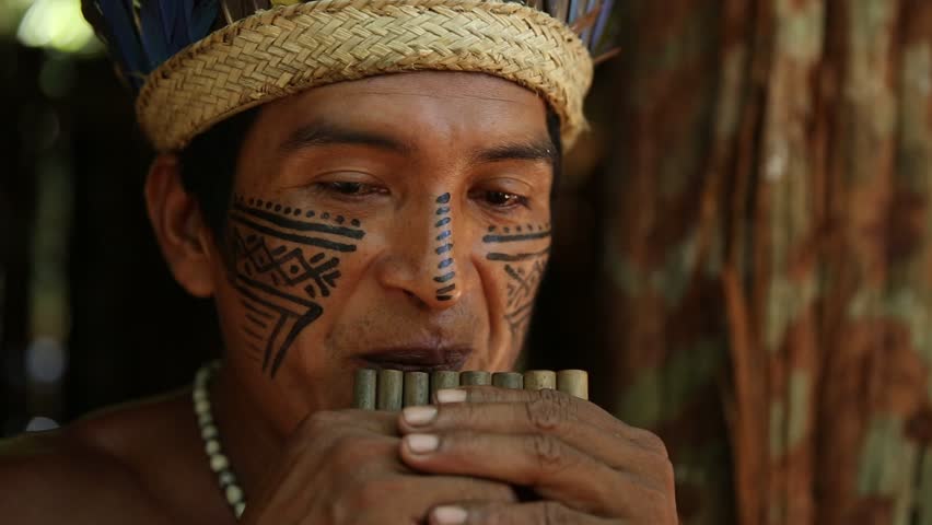 Native Brazilian playing wooden flute at an indigenous tribe in the Amazon Royalty-Free Stock Footage #11697284