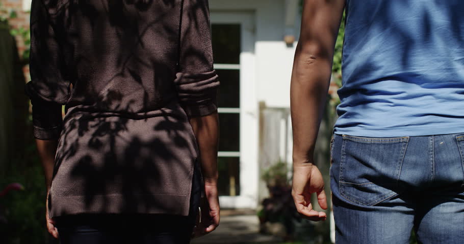 A young African American couple hold hands and walk into their new home. Shot on RED Epic.
