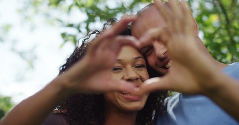 Closeup of loving couple making heart gesture together. Shot on RED Epic.