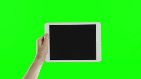 Female hand holding the new tablet on green screen. No need in green or blue screen into the tablet. You can track it easily putting the trackers on the screen corners. Cinema frame rate 23.97 fps.
