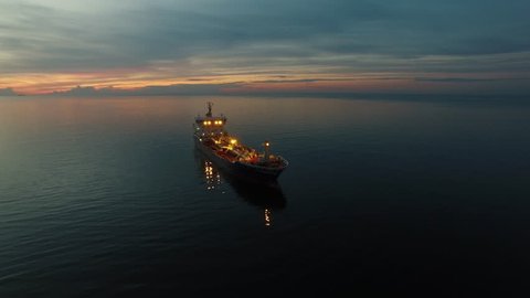 Aerial Orbit Shot of Tanker Ship Moving in Sea at Night. 