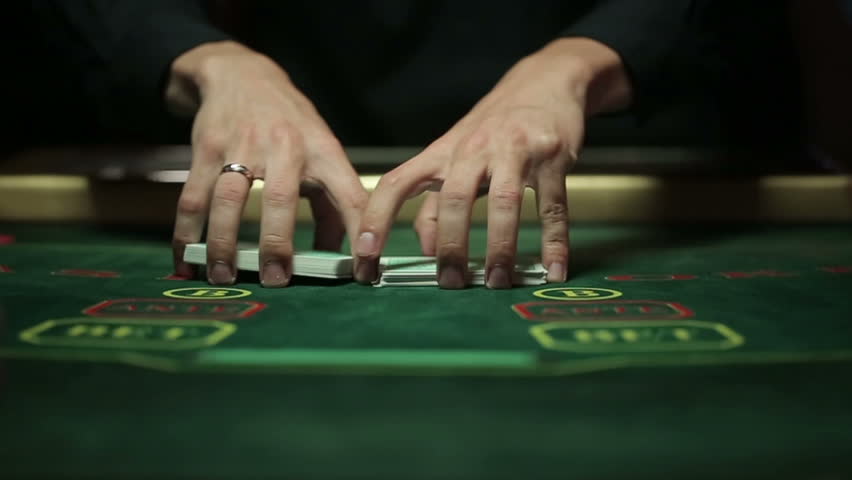 Casino, poker: Dealer shuffles the poker cards. Slow motion