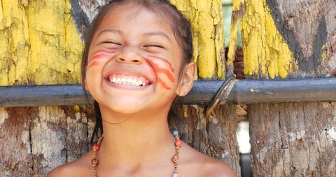 Cute native Brazilian girl smiling at an indigenous tribe in the Amazon