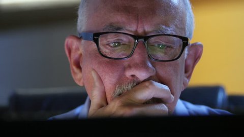 Older man talking back and upset at his computer