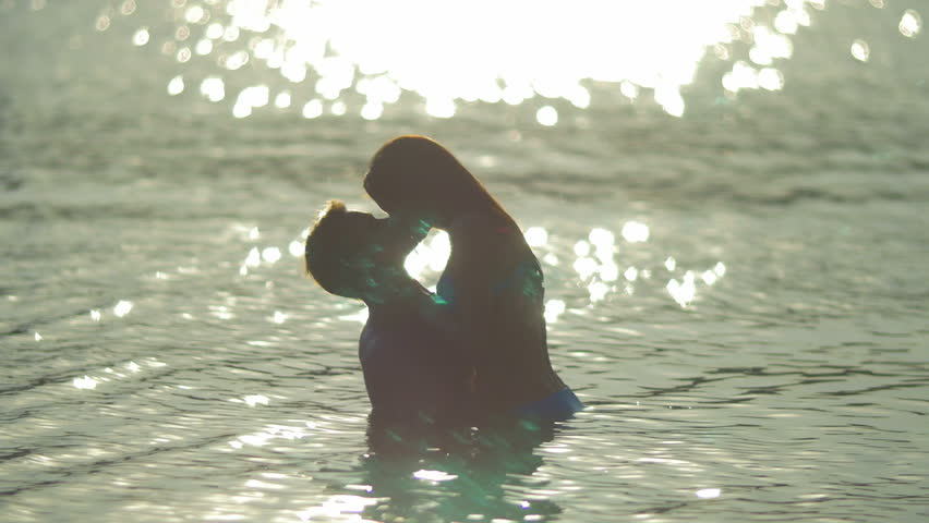 8 in 1 video! The couple (pair) walk on the beach and hug and kiss in the water with bright reflection surface. Real time and slow motion capture. 