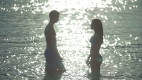 8 in 1 video! The couple (pair) walk on the beach and hug and kiss in the water with sunlight reflection. Real time and slow motion capture.
