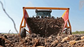 Potato digger at work ; Harvest potatoes from a tractor and a modern potato digger,video clip