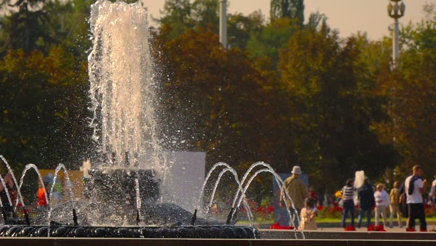Fountains in Moscow Exhibition Center, people walking,  slow motion, selective focus on foreground.