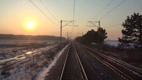 4K POV Point of view of train journey in winter morning, sun silhouette at sunrise or sunset 