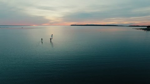 Aerial drone shot of windsurfer and paddleboarder at sunset. Shot in 4K (UHD).: stockvideo