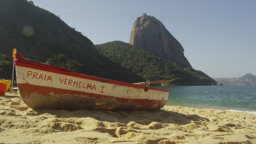 RIO DE JANEIRO - CIRCA JUNE 2013: Static shot of a single fishing skiff painted with "Praia Vermelha I" at Rio with Sugarloaf Mountain in the distance. Filmed June 19, 2013.