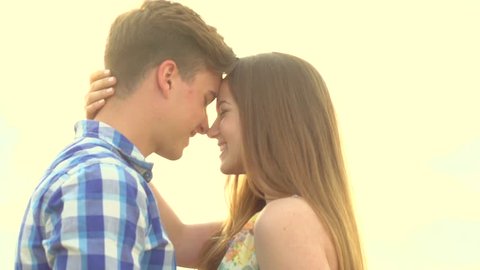 Teenage boy and girl hugging and kissing on wheat field. Young couple having date outdoors on meadow. Romantic. Relationship. Falling in love. Slowmotion. Slow motion HD 1080p