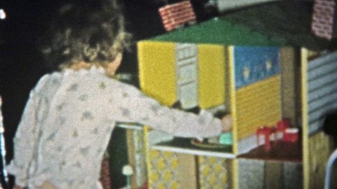 HARTFORD, CONN. 1957: Rich girl smiling playing with oversized dollhouse.