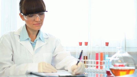 Attractive female scientist in laboratory smiling to camera 