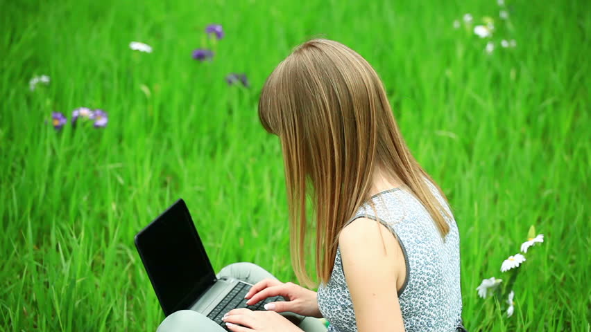 Young woman with laptop on the grass-1. Tripod static.