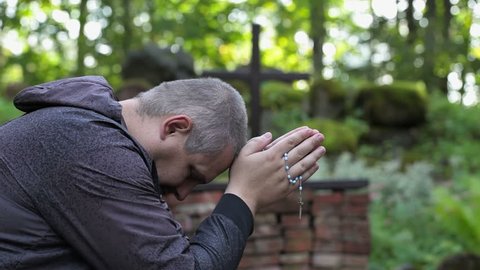 Man with the rosary praying at outdoors