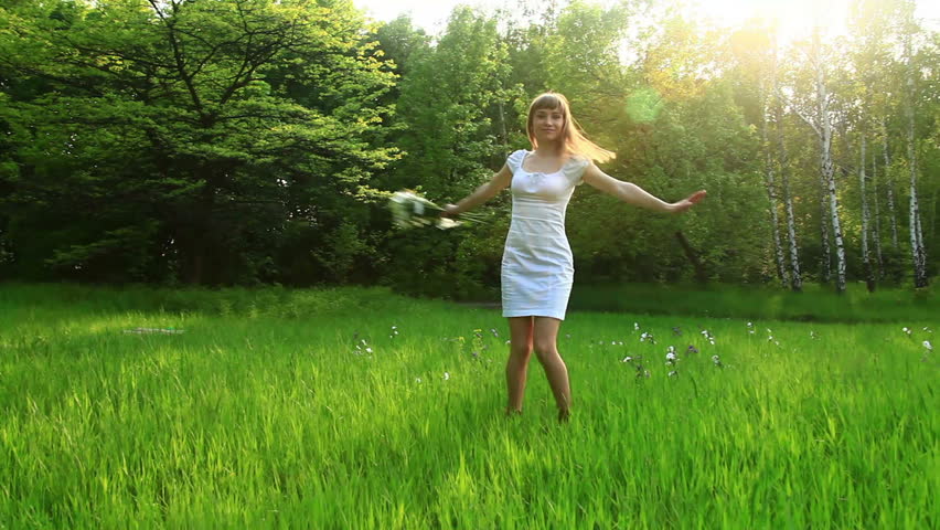 Beautiful woman spinning in the grass. Dolly HD 