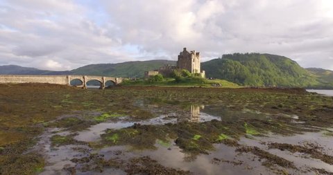 Stunning aerial shot of Eilean Donan castle in the Scottish highlands during good light with reflections of the castle in the water