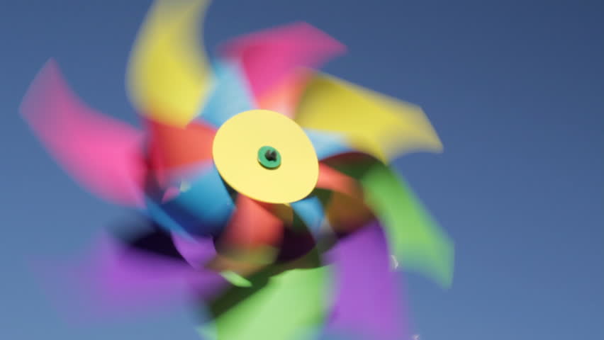 Child's windmill spins against perfect blue sky