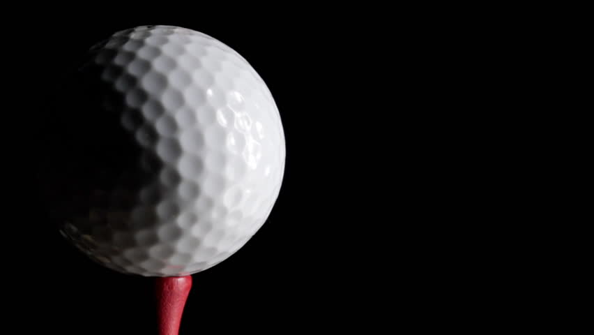 Loop of golf ball rotating against black background
