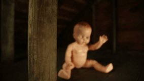 Fly at Baby Doll in Attic. 2 shots. Camera flys toward baby doll in an attic. two separate passes with different speeds. starts blurred and grabs focus at face creepy for Halloween footage.