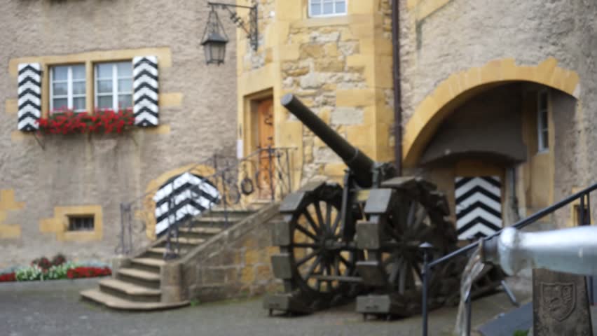 MURTEN, SWITZERLAND - CIRCA AUGUST 2015 Old gun and fountain in the inner yard of Town Hall
