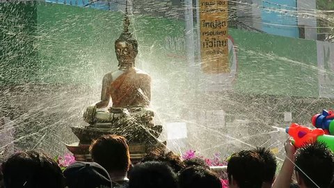 Bangkok, Thailand – April 14, 2014: People sprinkling at Buddha statue from water guns in Songkran Festival. One of the main activities to celebrate Thai traditional New Year is throwing water. 