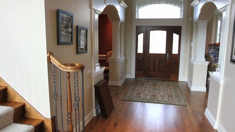 Panning from the main entryway, across the staircase, to the family room in a beautiful luxury house