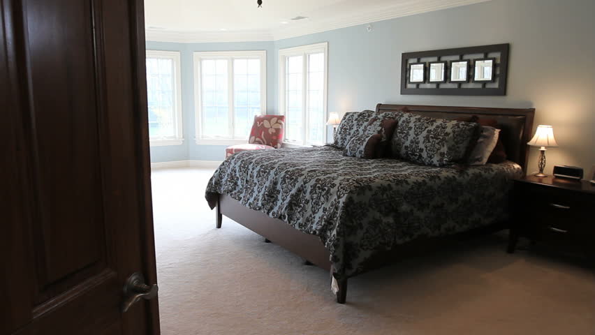 Moving dolly shot of a large master bedroom in a luxury house