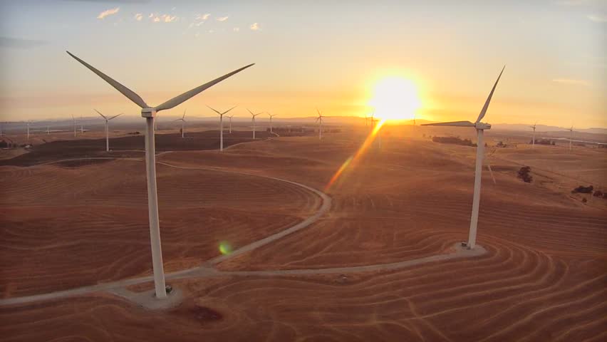 Tracking left along row of windmills looking into sunset with many windmills and mountains in the background. | Shutterstock HD Video #11855939