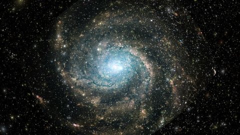Стоковое видео: A large spiral galaxy speeds toward the camera as stars fly past.