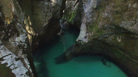 AERIAL: Blue river running through a narrow rocky gorge