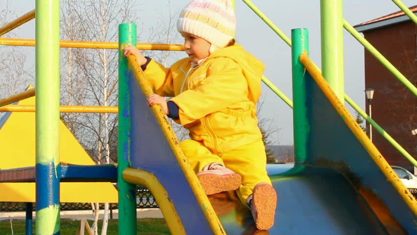 cute little girl in yellow on slide