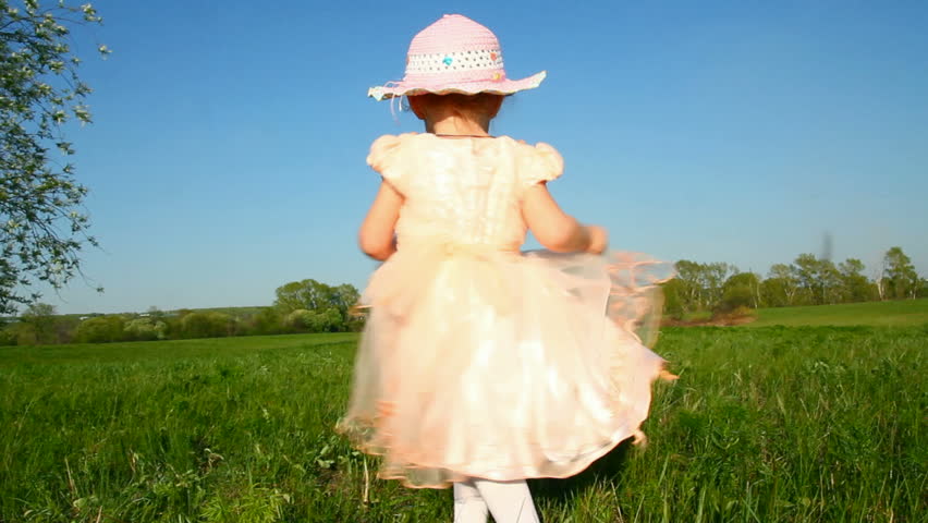 happy little girl in dress on meadow